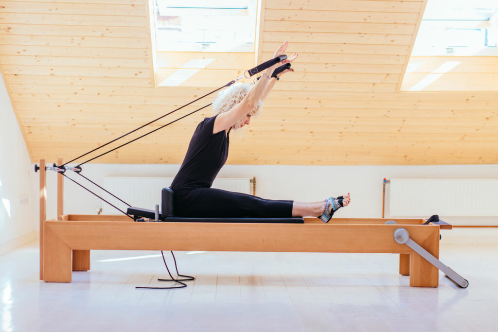Woman doing reformer Pilates at home