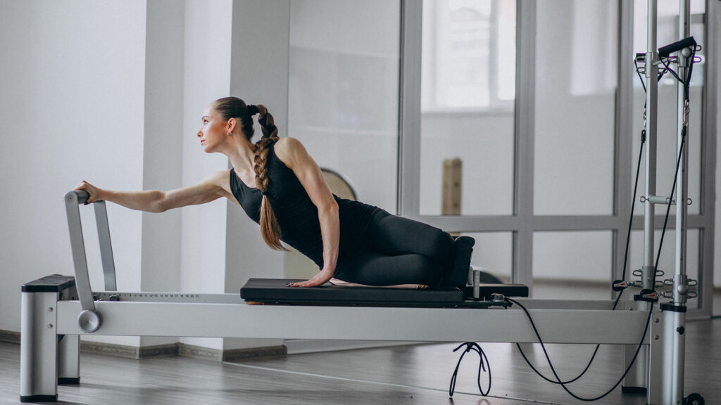 Person doing reformer pilates on demand
